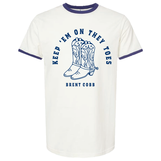 White t-shirt with blue ringer design featuring cowboy boots and text on a white background